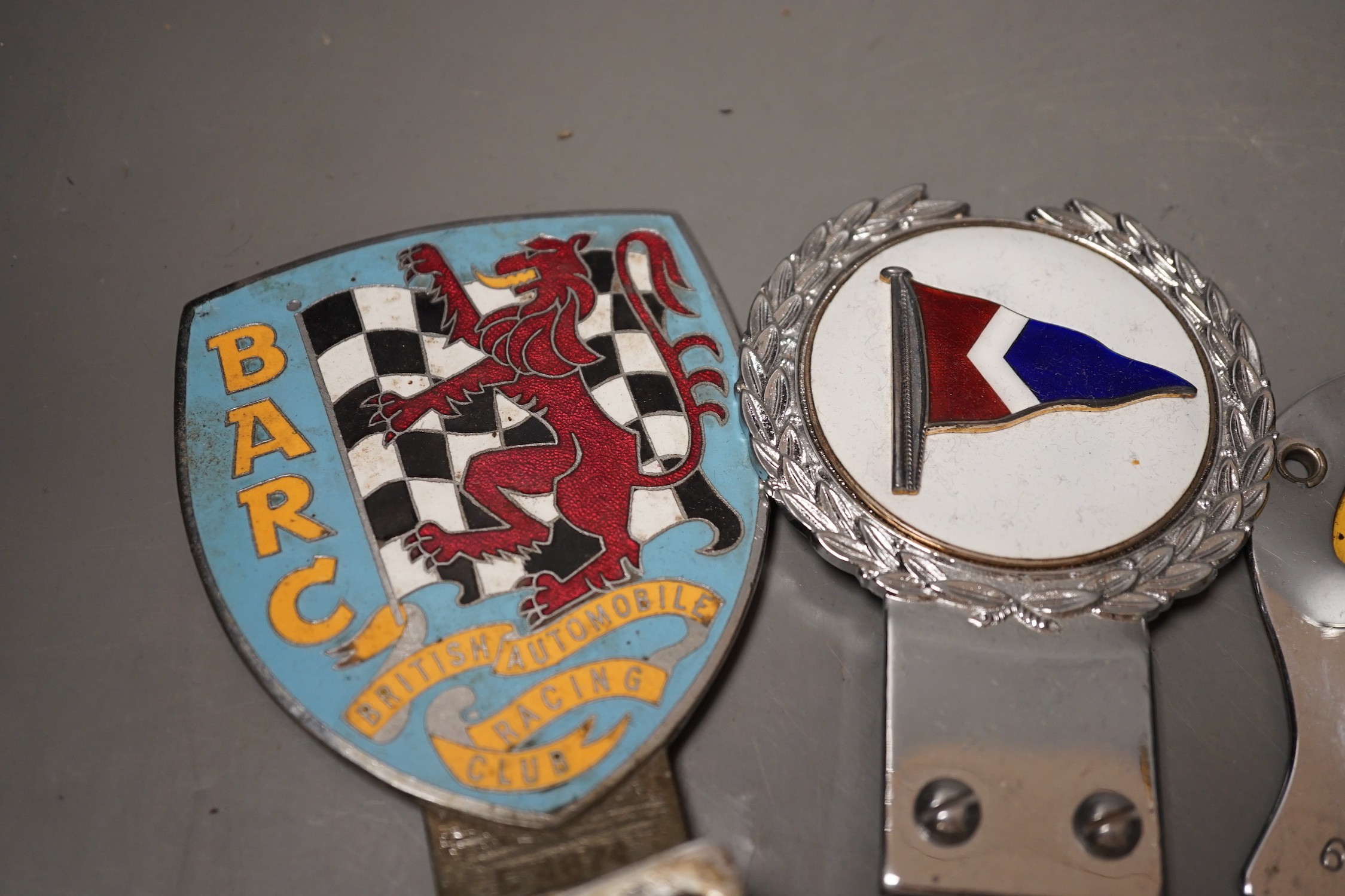 A British Automobile Racing Club car badge, an AA badge and one other